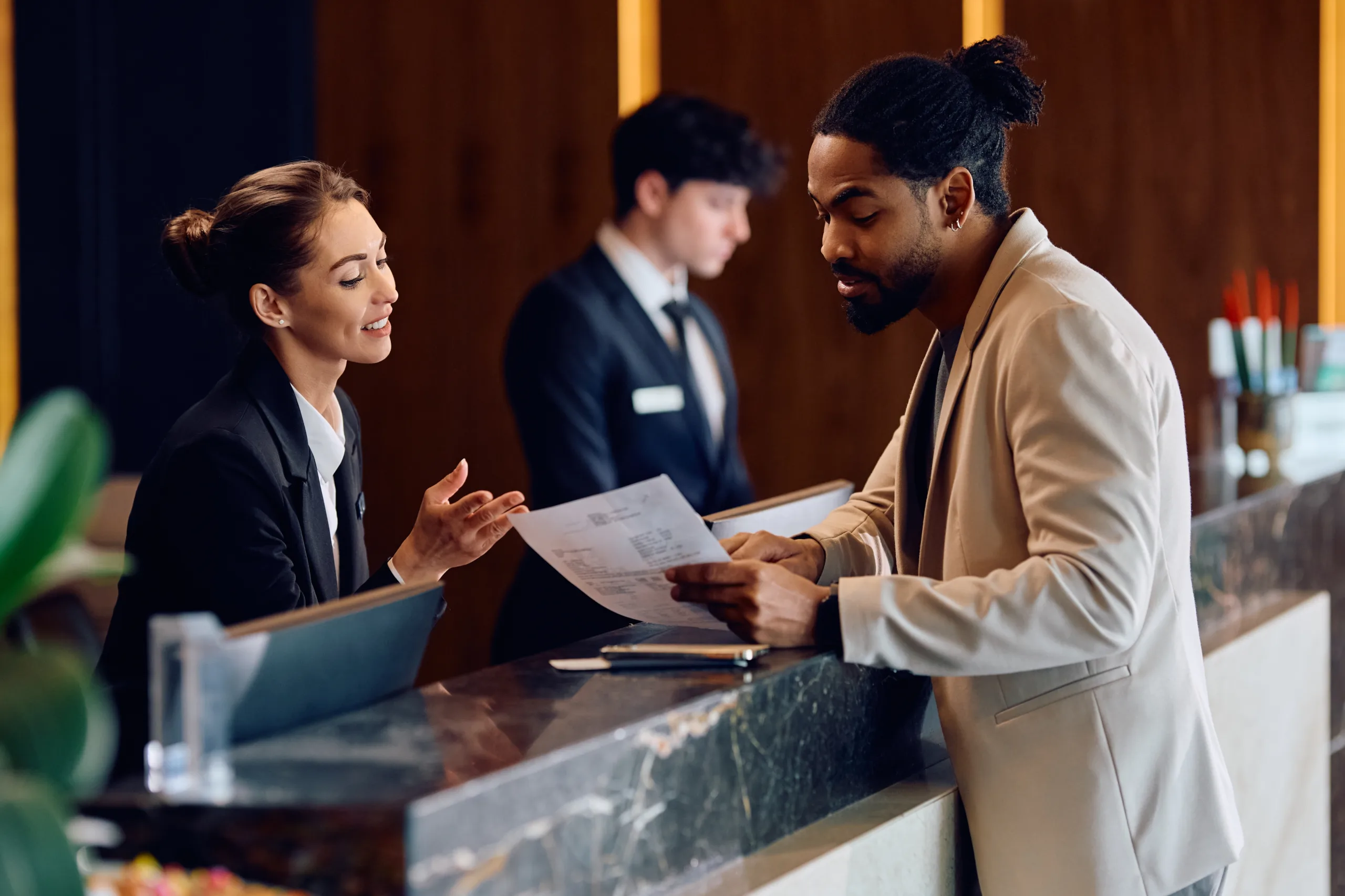 Smiling,Hotel,Manager,Assisting,African,American,Guest,In,Filling,Paperwork Tourism_1